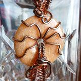 close up of gemstone donut wire wrapped in copper wire