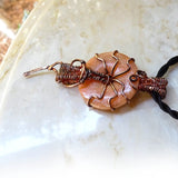 Side view salmon gemstone donut wire wrapped in copper