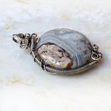 wire wrapped crazy lace agate in silver, tan, rust with patina