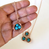 Hand holding Bird's Nest Pendant with Turquoise Eggs Handmade Copper Wire Wrapped jewelry