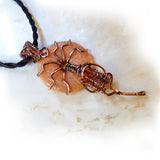 Side view of peach gemstone wire wrapped in copper